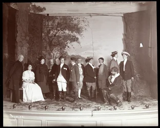 Die Besetzung auf der Bühne in Kostümen aus einer Amateurproduktion eines Stücks mit dem Titel 